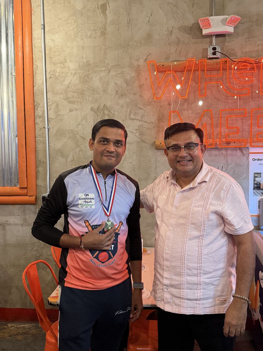 A coach with his medal alongside a program organizer