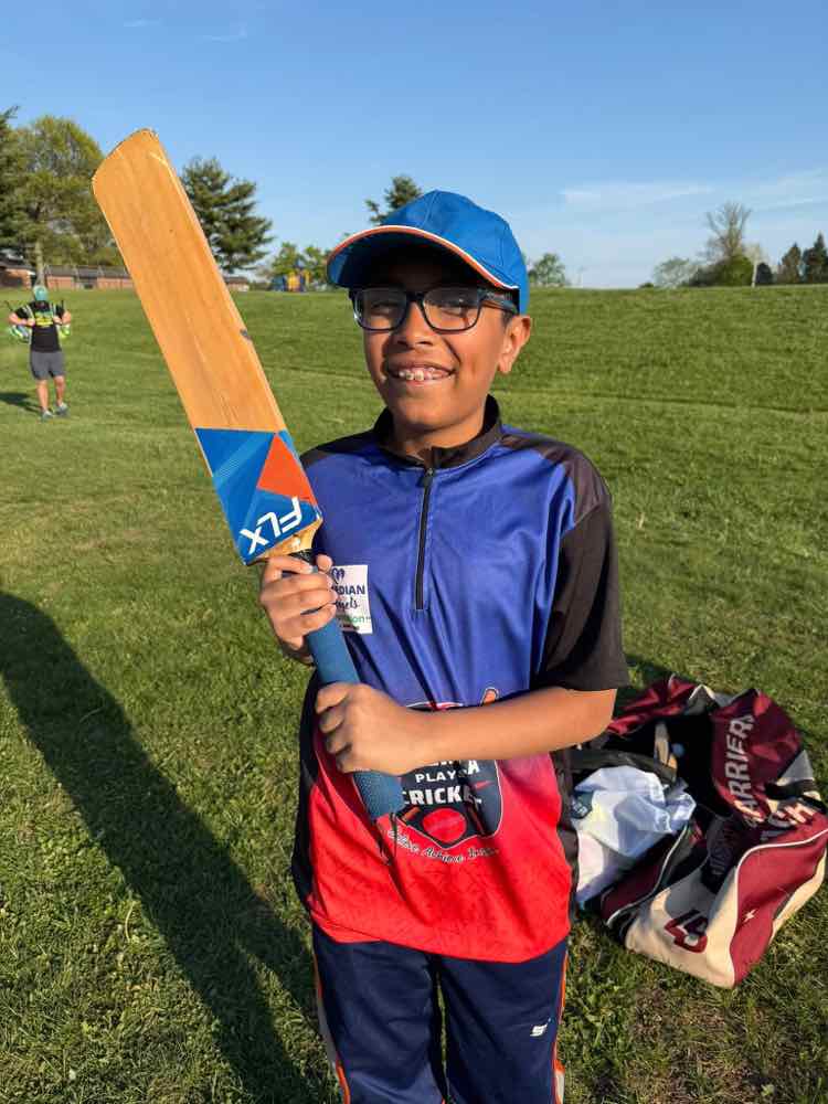 Young player holding his bat, smiling